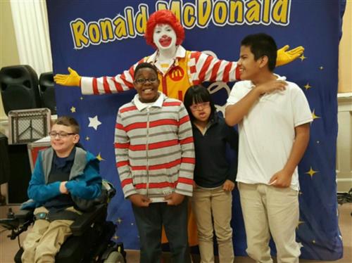 Four students with Ronald McDonald in auditorium 